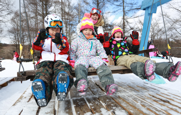 雪上ブランコで遊ぶ子供たち